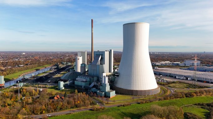 Luchtfoto van een moderne energiecentrale met koeltoren en staalconstructies.